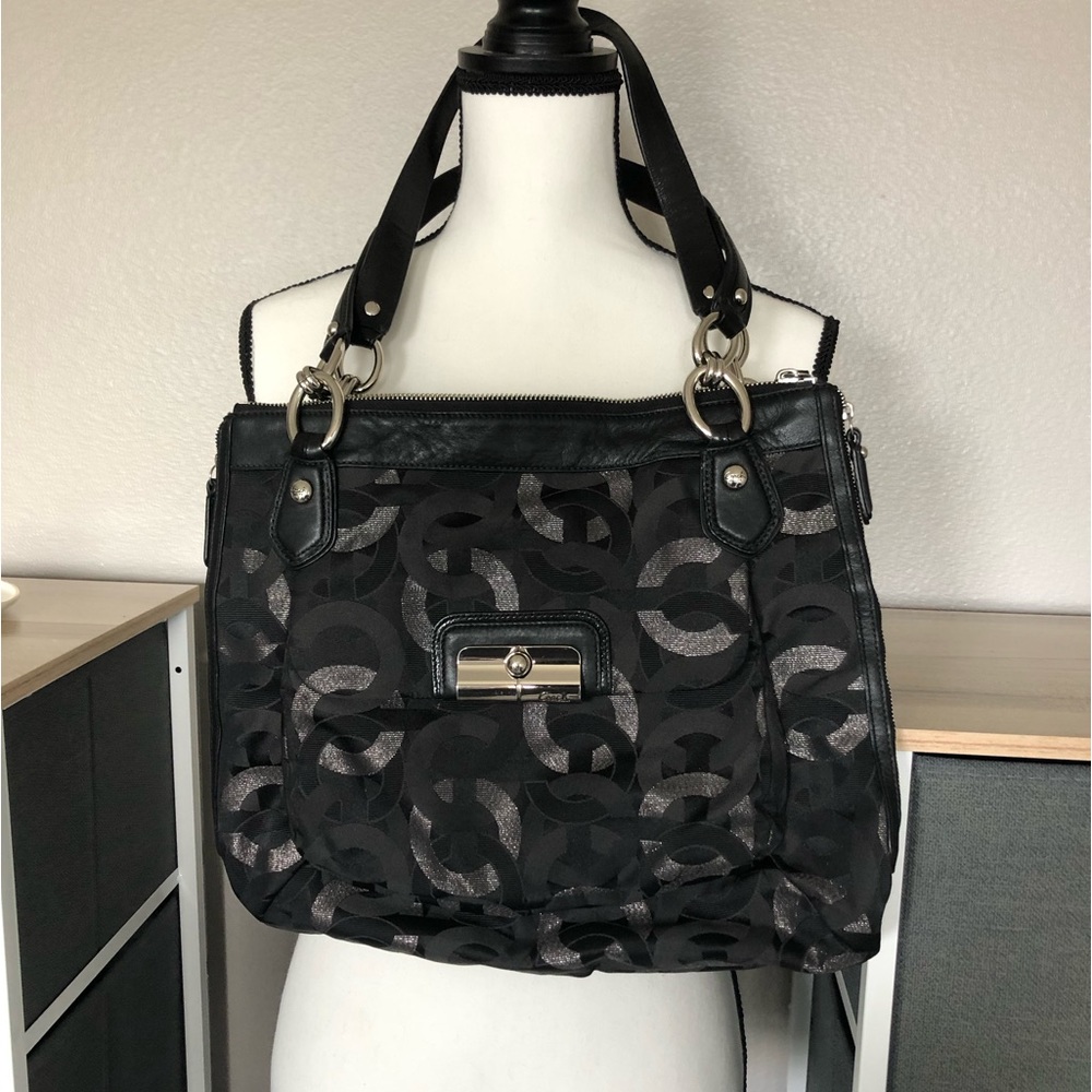 This is a black coach bag with silvery shadow circles inherent to the coach line